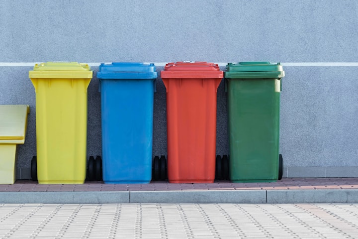 Colourful UK wheelie bins on a residential street — general waste, recycling, and garden waste bins ready for collection